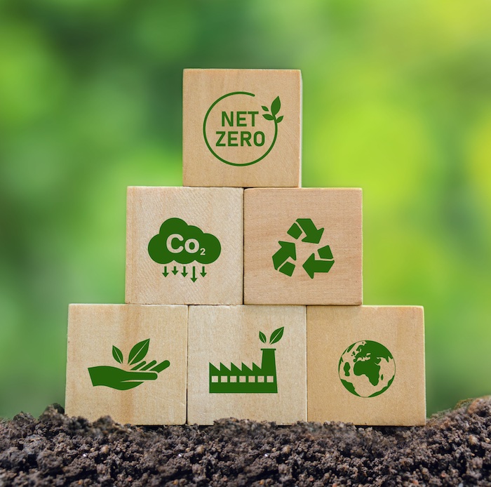 cartons stacked with icons stamped on: planet, industry, nurture, recycle, reduce CO2, NetZero